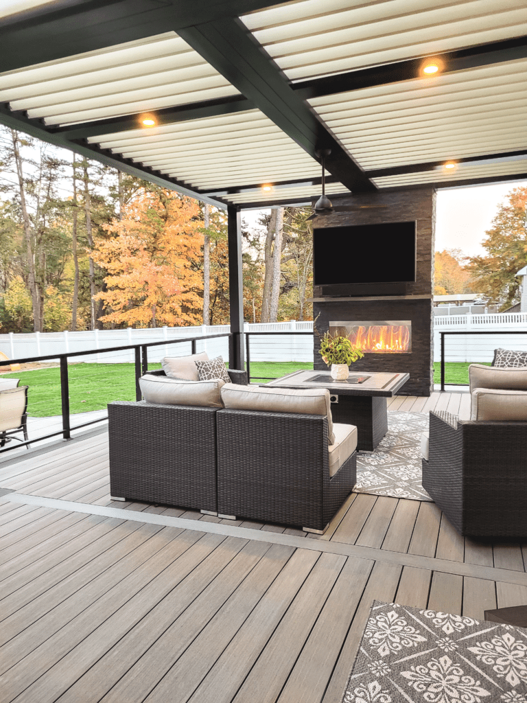 Outdoor living space with deck and fireplace by North Atlanta Exteriors
